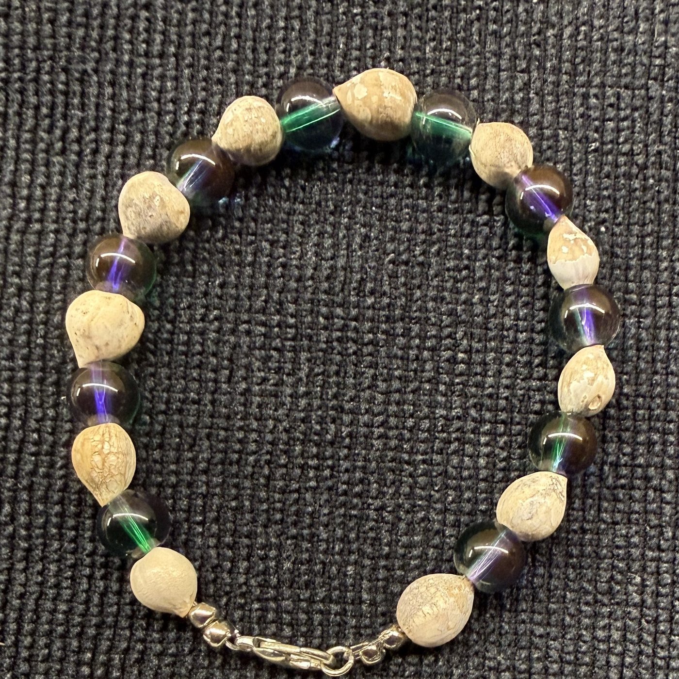 Bracelet 7, Northern Light, 7.5": dark iridescent glass beads with green and purple sheen alternating with cream Job's tears seeds and a silver clasp.
