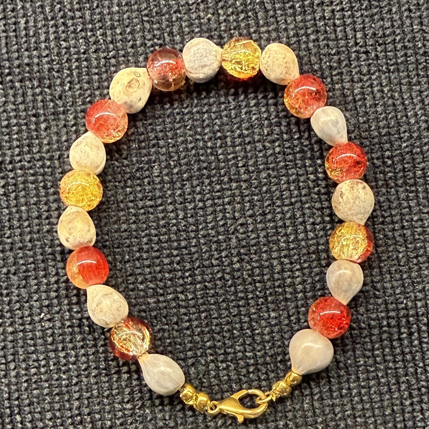 Bracelet 10, Pomegranate, 7.4": red, orange and golden crackle glass beads alternating with cream Job's tears seeds and a gold clasp.