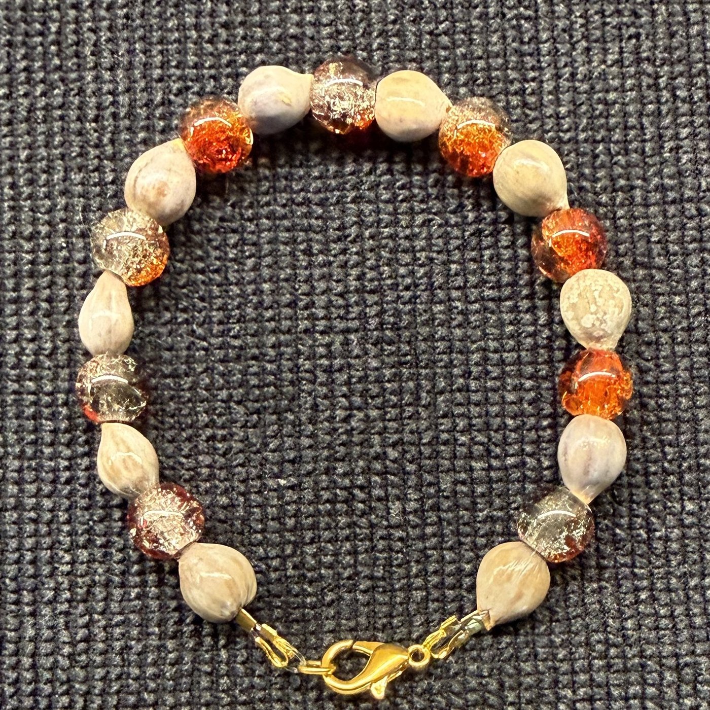 Bracelet 11, Sweet Tea, 7": orange, amber and clear crackle glass beads alternating with cream Job's tears seeds and a gold clasp.