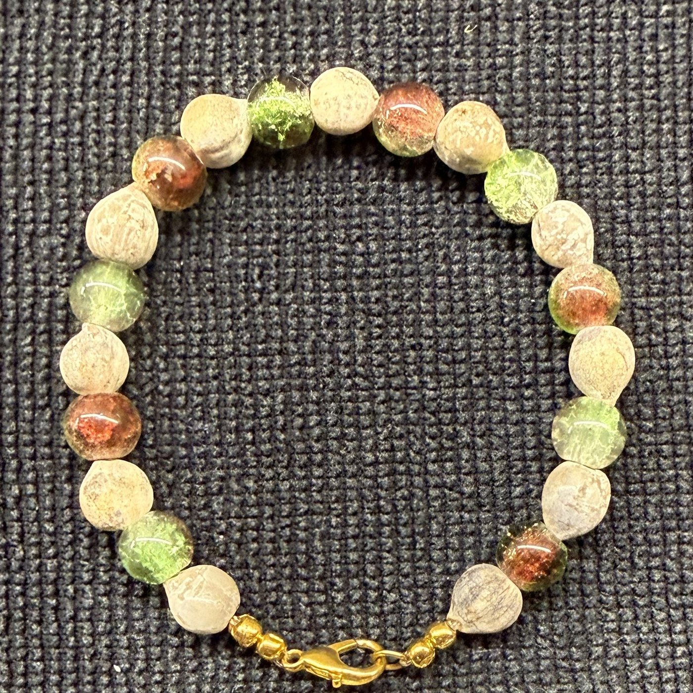 Bracelet 16, Camo, 7.4": olive green, brownish red and amber crackle glass beads alternating with cream Job's tears seeds and a gold clasp.